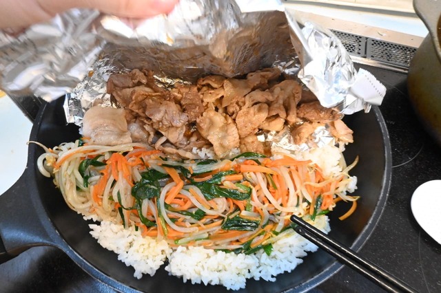 【ワンパン！石焼風ビビンバ】ホイルを引っ張り、ご飯の上に豚こま肉をのせます