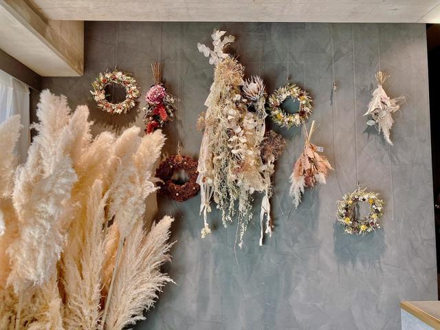 フラワーアーティストに作ってもらったドライフラワーが壁に飾ってあった／フキアージュ