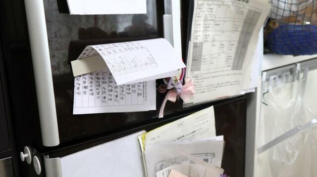 【BEFORE】スライドパネル使用前。冷蔵庫の扉はプリント類であふれ、必要な情報がなかなか見つからない状態でした…