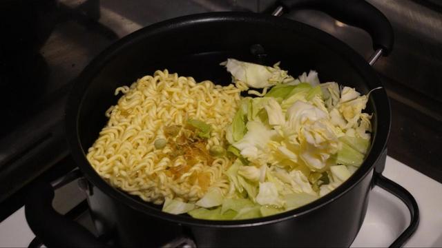 お湯を沸かして麺とかやく、具材を入れ、細かく切ったキャベツも投入。4分半後にザルにあげて湯をきります