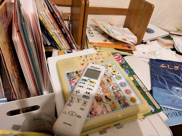 【整理整頓前】リモコンなど絵本やおもちゃ以外のものも積み重なりカオスな状態…