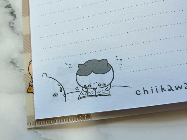 丸つけをしてあげているハチワレ。舌が出てしまっているのがかわいい…！