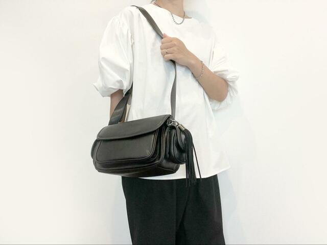 【niko and...　オリジナル6ポケットタッセルショルダーバッグ】白ブラウス×黒ボトムスのきれいめコーデにもしっくりなじみます！