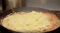 11．ソースにパスタを入れて、香りづけのエキストラバージンオイルを入れる