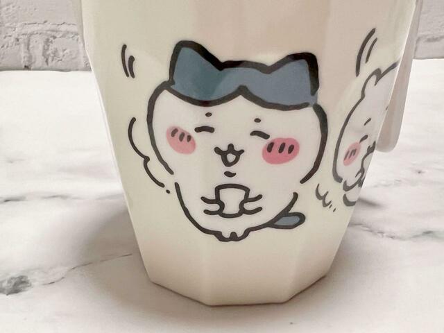 温かい飲み物を持って暖まっているハチワレ。小さなおててでカップを持っている様がかわいい…！