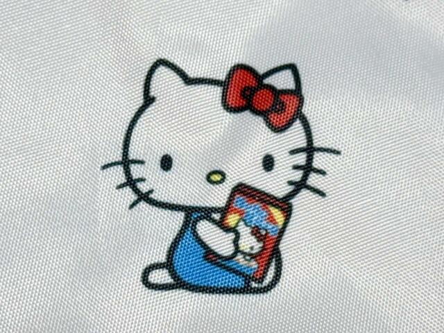 定番の横座り姿も披露。持っているお菓子のパッケージもキティちゃんデザイン!