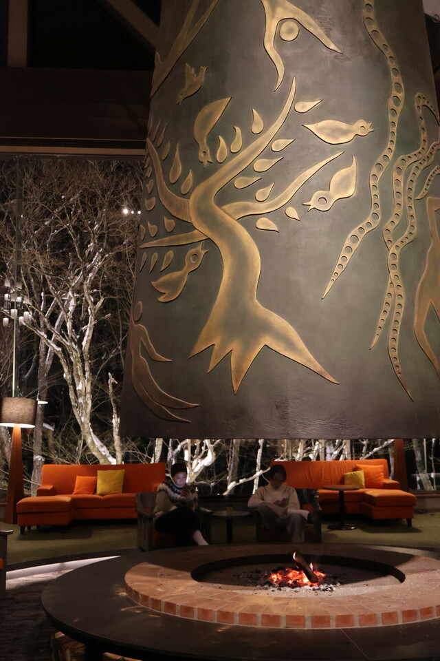 【星野リゾート　奥入瀬渓流ホテル】岡本太郎作の大暖炉「森の神話」は、鳥やきのこ、森の妖精が暮らしている様子を表しています