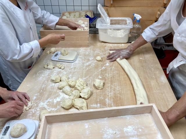 セントラルキッチンから届いた皮を１個１個手切している／東京豚饅