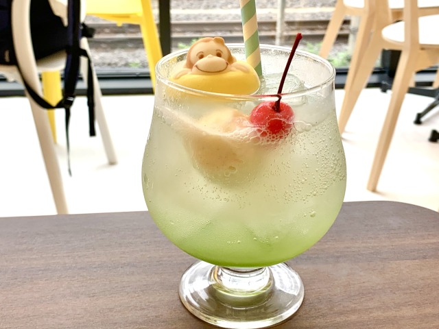 うきわで遊ぶジョージのマシュマロがのった、カラフルなクリームソーダ。