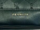 フロント下部は無地の合成皮革生地に切り替えられており、「PEANUTS」のロゴがゴールドで型押しされています