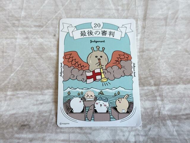 「20．最後の審判」は復活や再生を意味するカード。『ウェイト版』のイラストを模していますが、キャラの配置が絶妙！ラッパを吹いているのは天からの言葉を伝える大天使、ガブリエル。このキャラは、ラッコが強くなると誓った銅像です。どんな意味が隠されているのか気になる…！