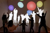 《Immersive Shadow: Bubbles》 藤本直明 ©naoaki FUJIMOTO／壁に映し出されたカラフルなボールを、自分の影でさわったり弾いたりすることができます。