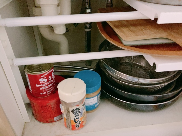 【ニトリ シンク下伸縮ラック使用後】下にフライパンや鍋、2段目にトレイ、3段目に小さめのフライパン、余ったスペースに調味料が収まりスッキリ…！