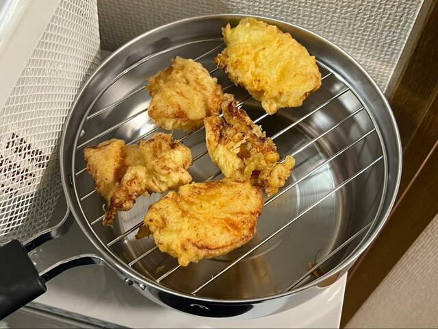 【揚げてお仕舞い】揚げ上がった鶏肉は油きり網にのせ、油を切ります
