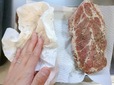 【ダイソーグッズで自家製ベーコン作り】フリーザーバッグから肉を取り出し、表面に出た水分をキッチンペーパーでふき取ります
