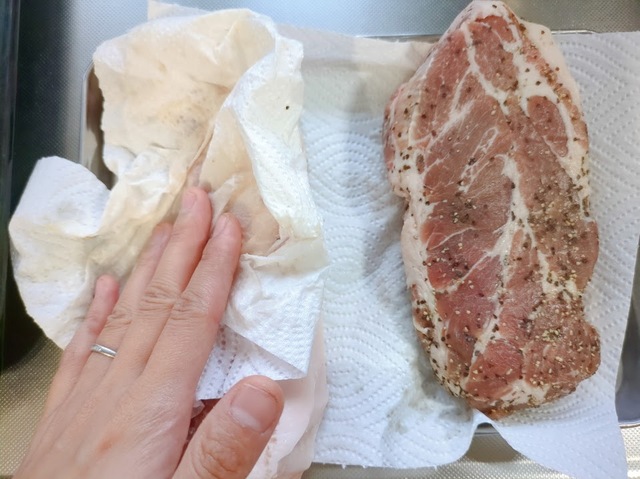 【ダイソーグッズで自家製ベーコン作り】フリーザーバッグから肉を取り出し、表面に出た水分をキッチンペーパーでふき取ります
