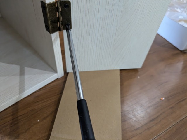 【ニトリ トイレ収納（トゥール）】扉の取付時には、段ボール片を下に挟むとちょうどよい高さでねじが締めやすくなりました