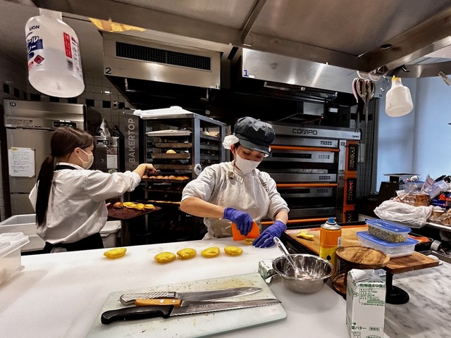 【レストラン ル ボヌール】「ブーランジェリー ル サンク」の厨房。女性スタッフがパンを作っていた