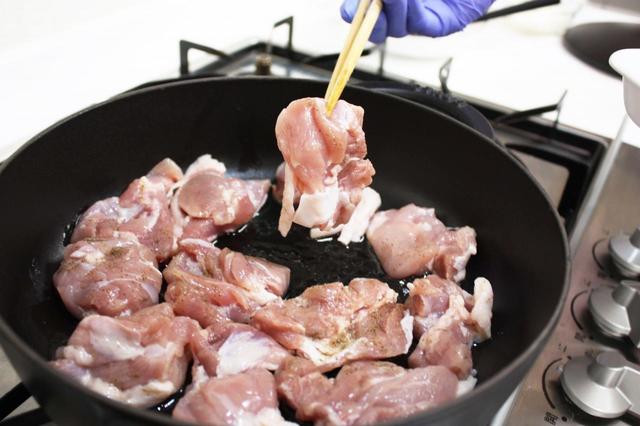 油が温まったら、鶏肉を皮目から炒める