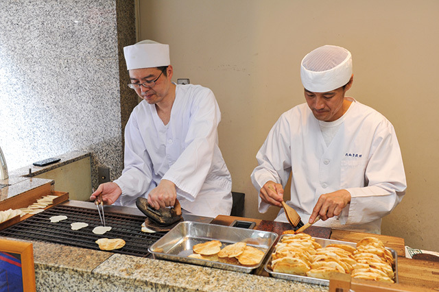 麻布十番 たぬき煎餅／三代目の日永治樹氏が黙々と煎餅を焼く（実演は12：00～15：00）