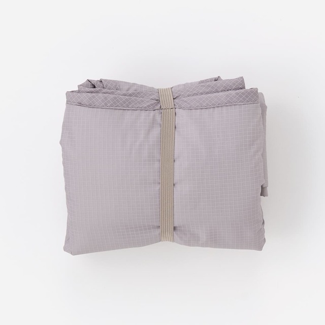 【KEYUCA「レジカゴ1個分の保冷エコバッグ」】左右を折りたたみ、くるくる丸めてゴムバンドで留めるだけで手のひらサイズにまとまります