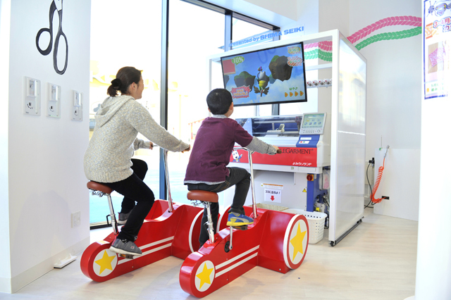 「FASHION factory」／マイニットは、自転車やボートをこいだり、ランニングをしたりすると、その動力でコースターを編んでくれる