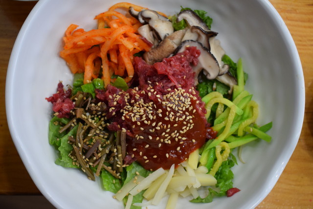 『コサン・ミソ』のユッケビビンパは野菜もたっぷり。なかでも右上のシイタケは肉厚で風味豊かだった。韓国人は上にかかっている甘辛のタレが全体によくゆきわたるように念入りにかき混ぜるが、日本の人には適度にまぜて、肉や野菜そのものの味を生かすように食べてもらいたい