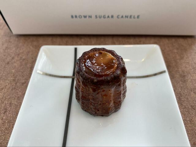 【黒糖カヌレほうき星】焼き上げた後は、トッピングのミルクソースがとろっとして美味しそう！