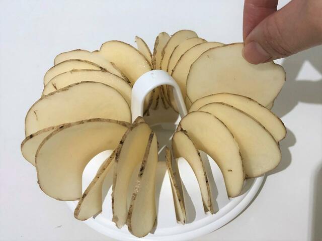 ジャガイモをチップスメーカーの仕切りの部分にひとつずつ並べて
