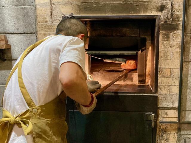 薪窯の上段にパンを並べて焼いているという