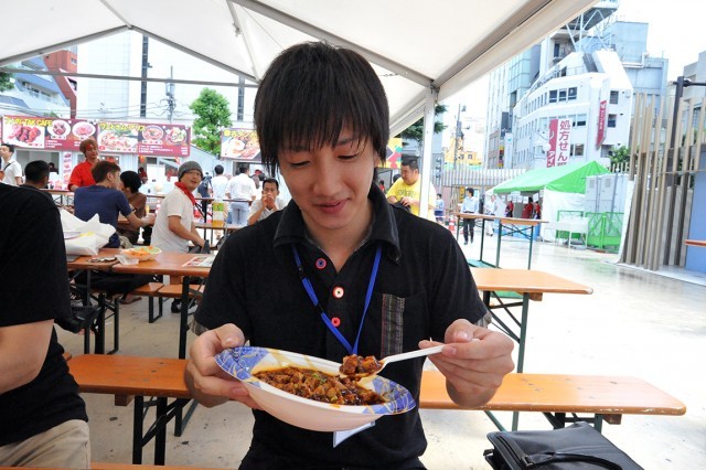 激辛グルメ祭り／京華楼の「本場の四川麻婆豆腐（S）」（600円）を、けっこうイケると笑みを浮かべて食べるライター菊池。辛いものへの苦手意識が払拭されたか！