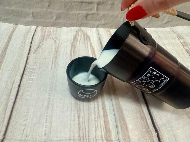 おちょこにホットミルクを注ぐ図