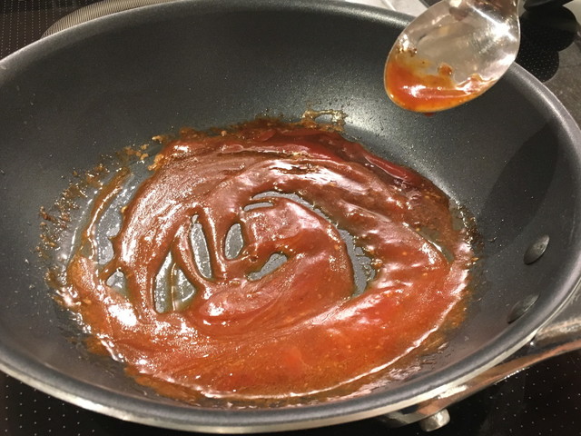 （8）ハンバーグを焼いたフライパンでソースを作る。赤ワインを入れ、アルコールを飛ばす。マスタード、中濃ソース、ケチャップ、醤油を入れ、濃度が出るまで弱火で煮詰める。それぞれの量はお好みで